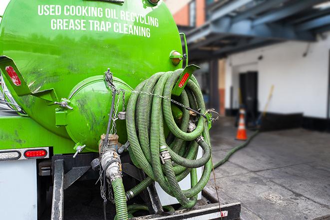 a technician pumping a grease trap in a commercial building in Paradise Valley